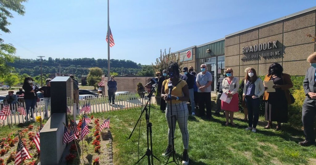 An outdoor press conference during COVID surrounding the proposed Regional Police Department in the Mon Valley Area. A group of people stands outside the Braddock Municipal Building in Braddock, PA 