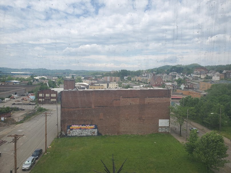 An aerial photo of Braddock Borough taken in front of a dirty window. 