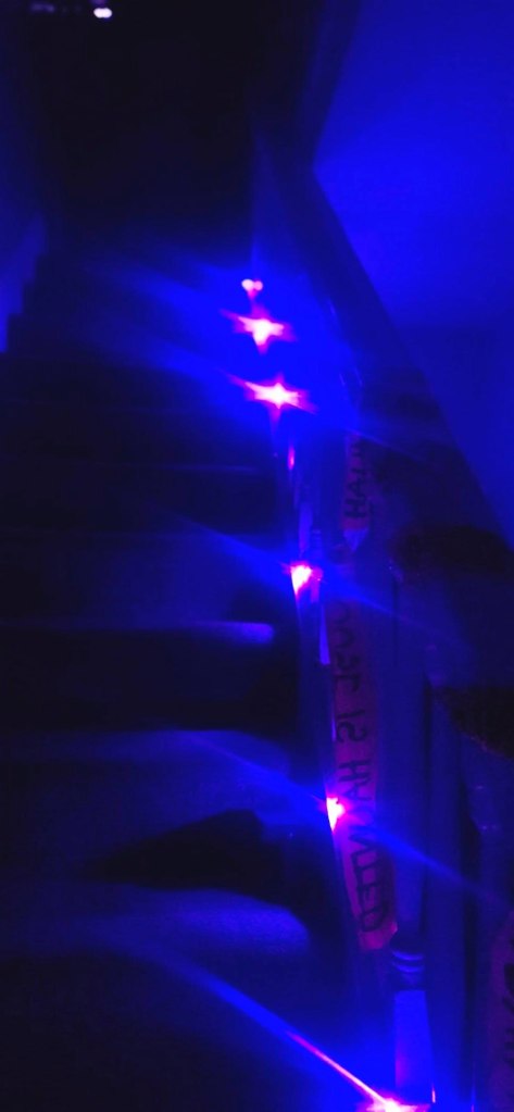 A blurry photo of flashing Halloween Lights showcasing that I keep them up all year round just in case I need some light to lead the way.